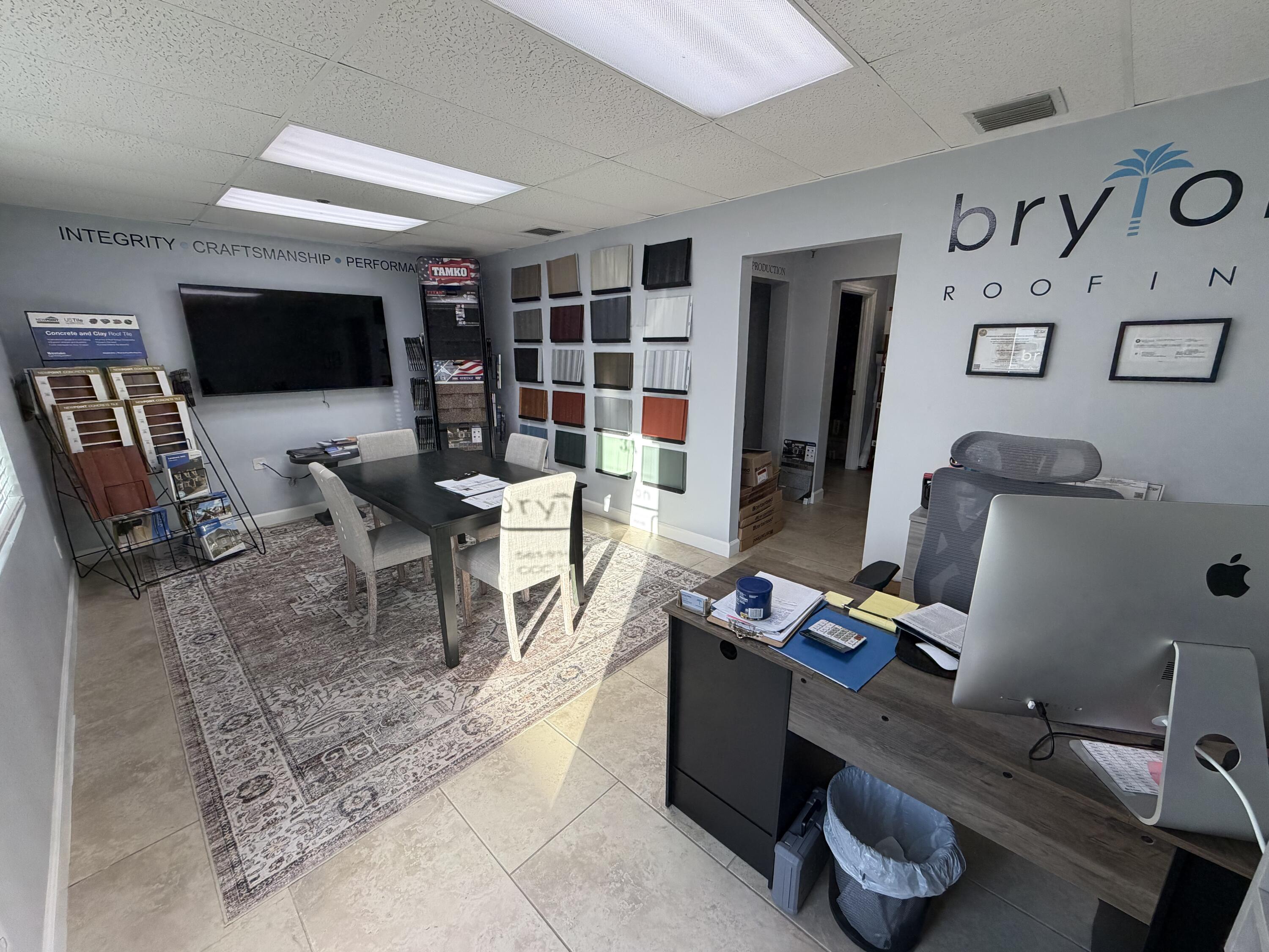 1312 Commerce Lane, Unit 3A Jupiter, FL 33458 - Photo 3 of 10 a work room with furniture a flat screen tv and bookshelf