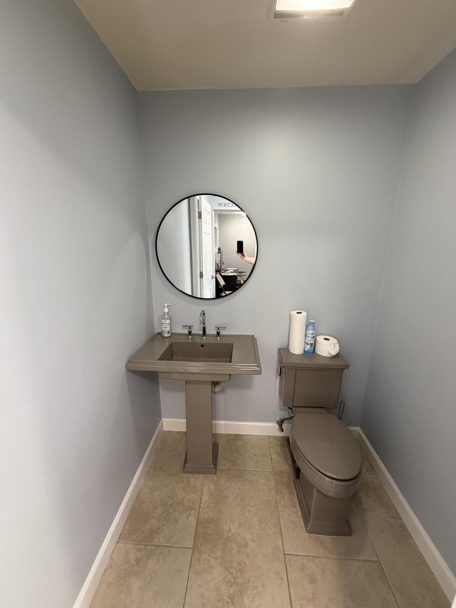 1312 Commerce Lane, Unit 3A Jupiter, FL 33458 - Photo 7 of 10 a bathroom with a toilet a sink and a mirror