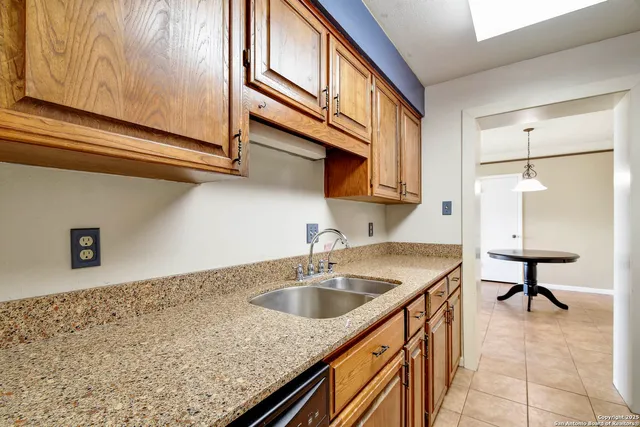a kitchen with stainless steel appliances granite countertop a sink and a refrigerator
