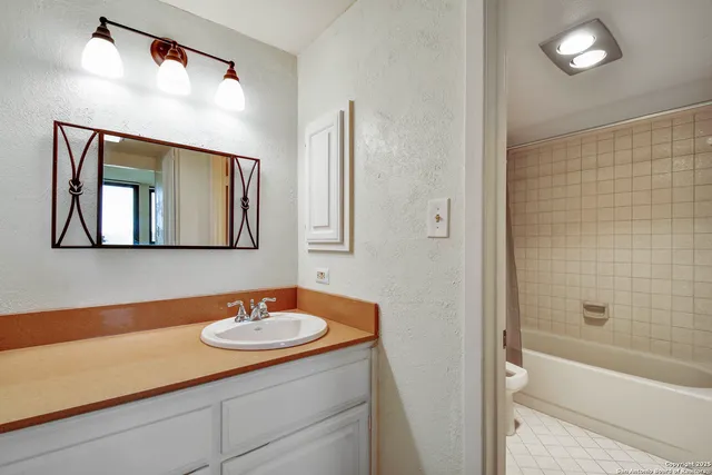 a bathroom with a sink a light fixture and a mirror