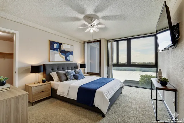 a spacious bedroom with a large bed and a chandelier