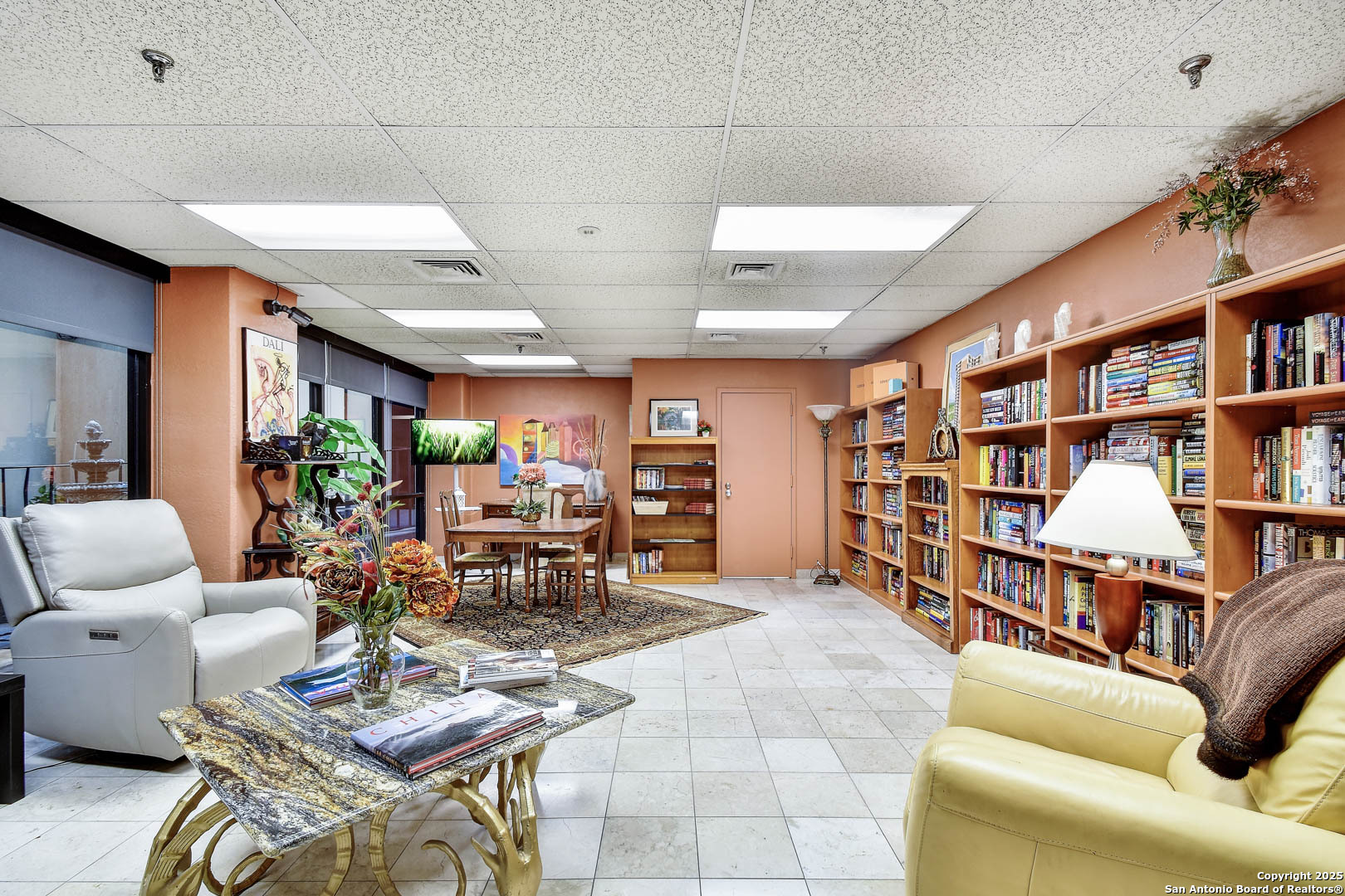 7701 Wurzbach Road, Unit 405 San Antonio, TX 78229 - Photo 28 of 42 a living room with lots of furniture and a book shelf
