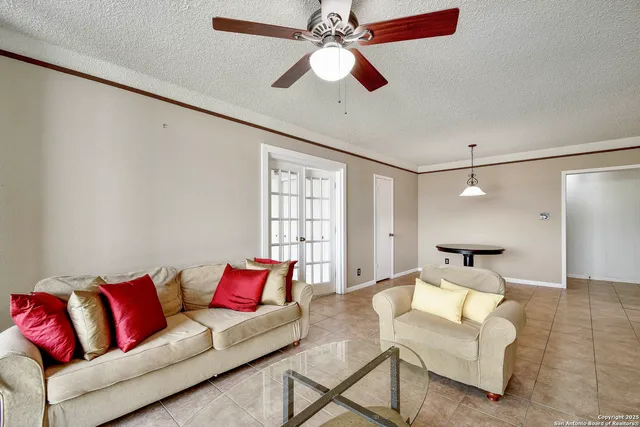 a living room with furniture and a ceiling fan