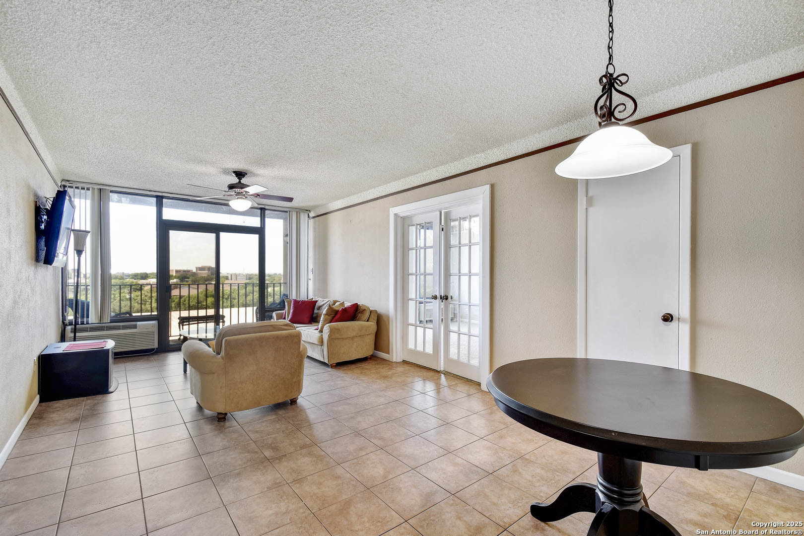 7701 Wurzbach Road, Unit 405 San Antonio, TX 78229 - Photo 7 of 42 a living room with furniture and a chandelier