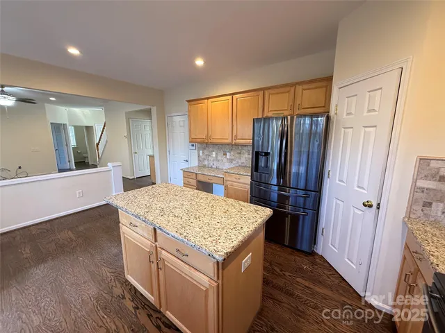 a kitchen with stainless steel appliances granite countertop a refrigerator and a sink