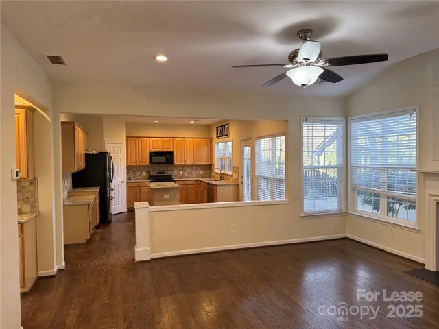 a view of a big room with wooden floor windows and a kitchen