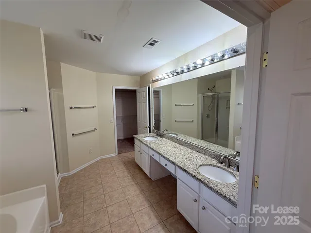 a spacious bathroom with a double vanity sink and a mirror