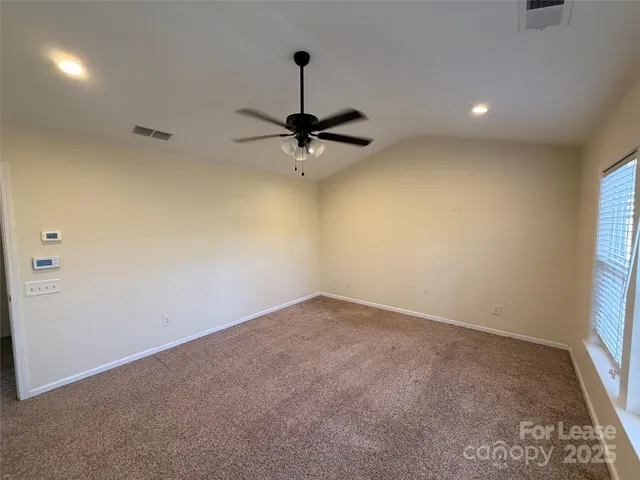 an empty room with a window and a ceiling fan