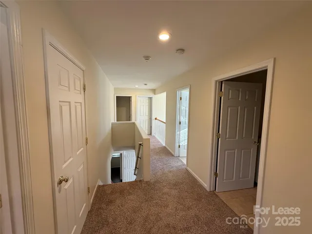 a view of a hallway with closet and wooden door