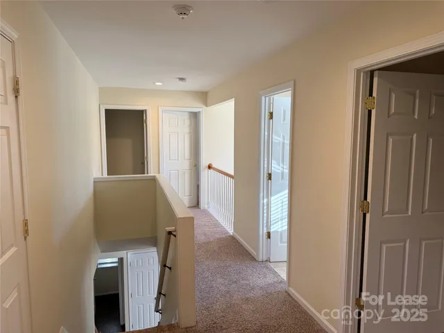 a view of a hallway with windows and closet