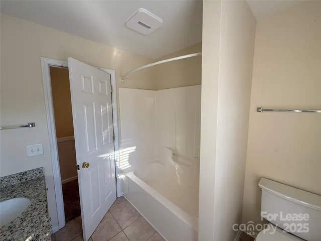 a bathroom with a tub shower and a sink