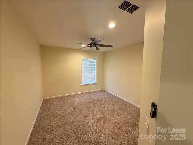 a view of a livingroom with a chandelier fan and a window