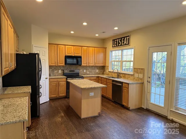 a kitchen with stainless steel appliances granite countertop a refrigerator stove and sink