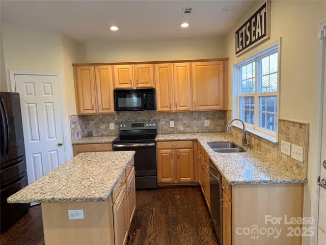 a kitchen with a sink stove top oven and refrigerator