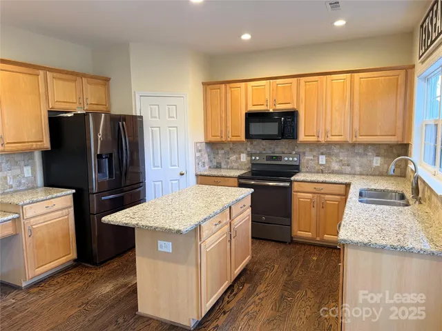 a kitchen with a refrigerator stove top oven and sink