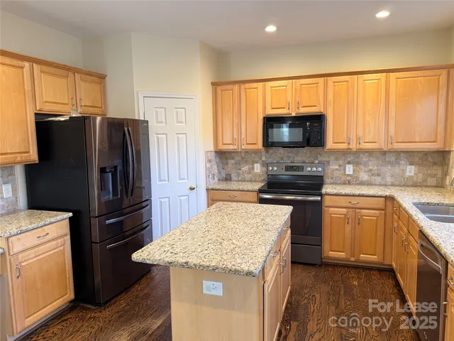 a kitchen with stainless steel appliances granite countertop a refrigerator stove microwave and sink