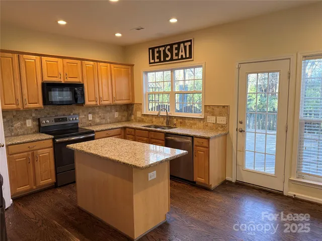 a kitchen with stainless steel appliances granite countertop a sink stove and microwave