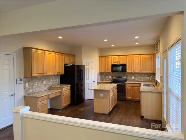 a kitchen with a refrigerator and a stove top oven