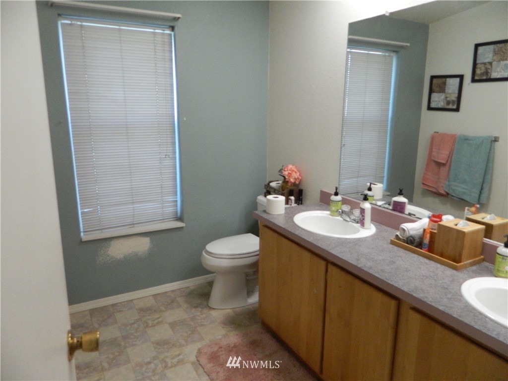 41 Miller Road Omak, WA 98841 - Photo 22 of 27 a bathroom with a granite countertop sink a toilet and a mirror