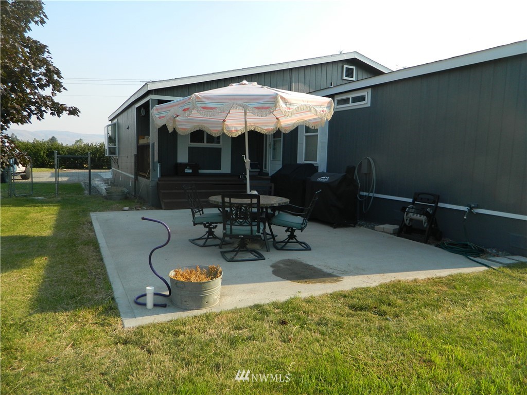 41 Miller Road Omak, WA 98841 - Photo 4 of 27 a view of a patio with couches table and chairs under an umbrella