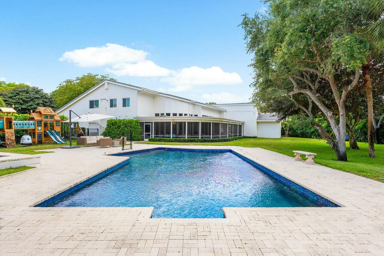 4356 Kasso Circle Boca Raton, FL 33487 - Photo 2 of 72 a view of house with swimming pool outdoor seating and trees in the background