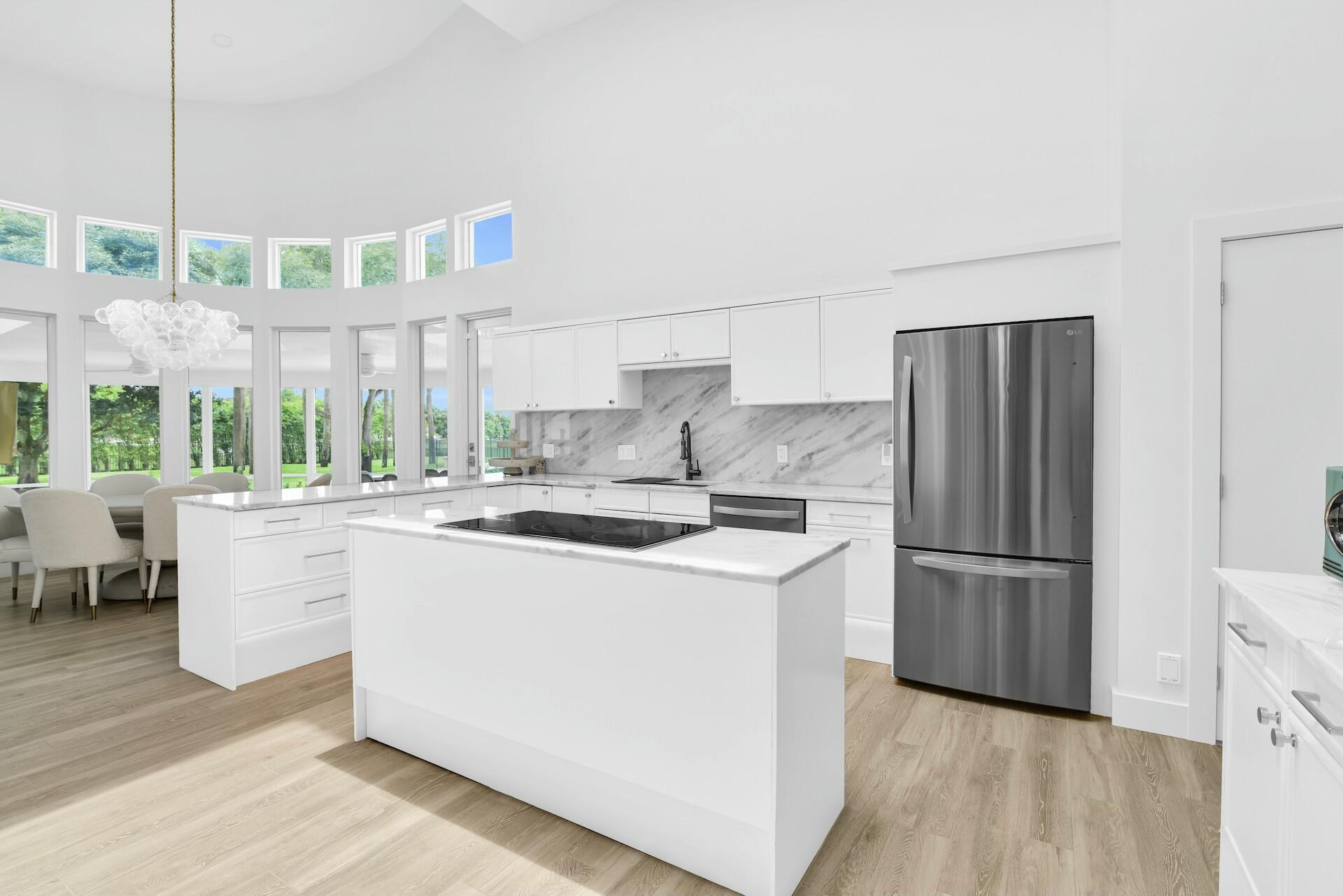 4356 Kasso Circle Boca Raton, FL 33487 - Photo 24 of 72 a kitchen with kitchen island wooden cabinets and refrigerator