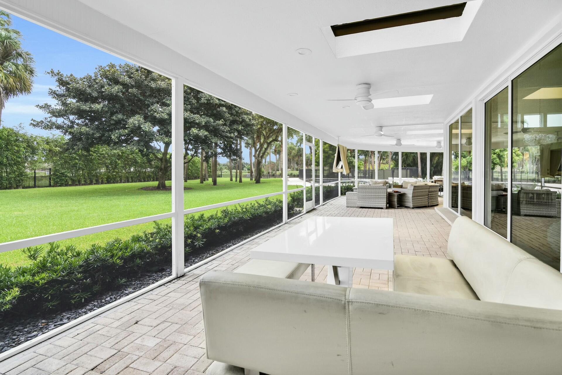 4356 Kasso Circle Boca Raton, FL 33487 - Photo 30 of 72 a view of a patio with table and chairs potted plants with floor to ceiling window