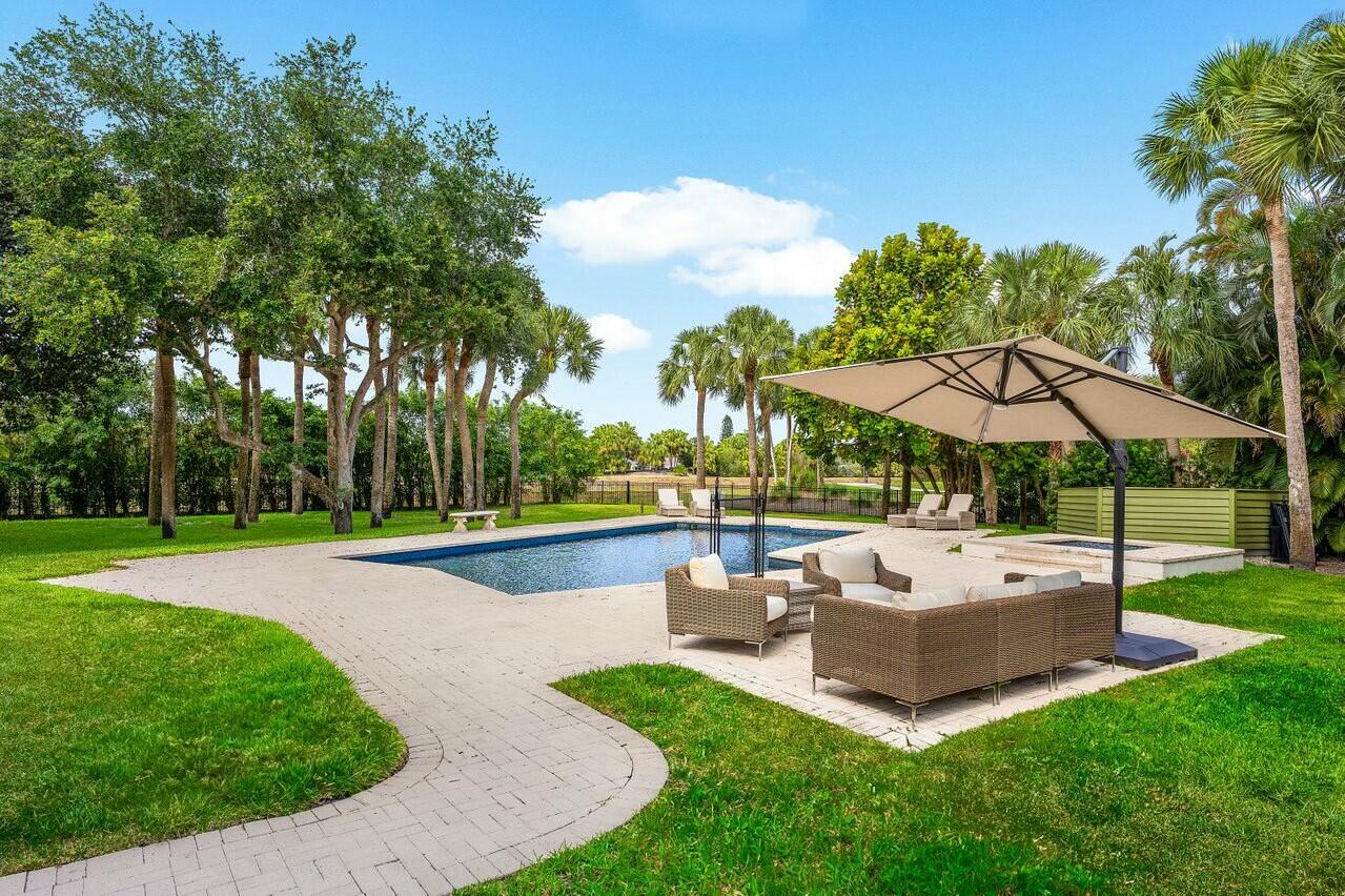 4356 Kasso Circle Boca Raton, FL 33487 - Photo 3 of 72 a view of pool with table and chairs under an umbrella