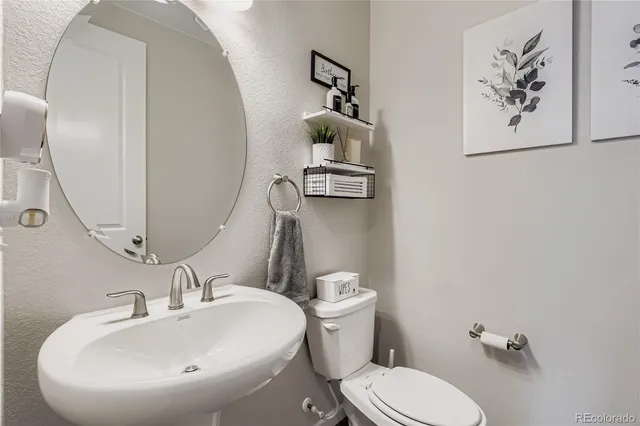 a bathroom with a sink mirror and toilet