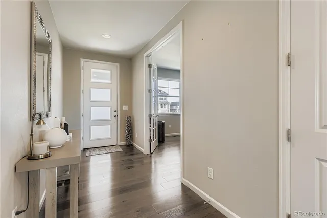a hallway with wooden floor windows and a livingroom