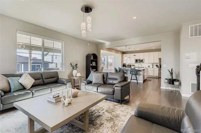 a living room with furniture kitchen view and a large window
