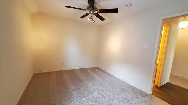 an empty room with a window and a ceiling fan