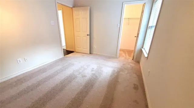 an empty room with windows and a ceiling fan