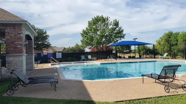 a view of a swimming pool with a bench and wooden fence