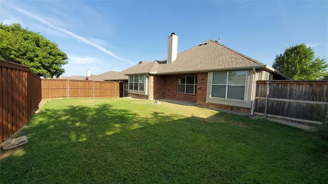 a front view of a house with a yard and potted plants