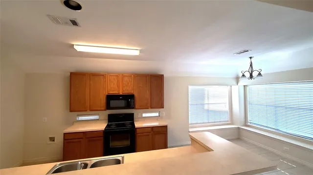 a kitchen with granite countertop a stove and a refrigerator