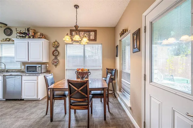 a dining room with furniture a chandelier and wooden floor