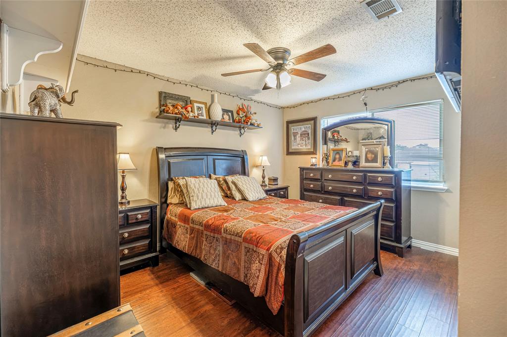 3103 Scott Drive Sachse, TX 75048 - Photo 19 of 26 a bedroom with a bed and a chandelier