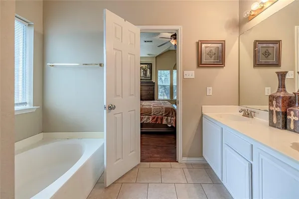 a en suite bathroom with a tub sink and view bedroom