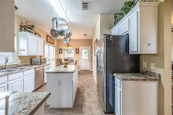 a kitchen with cabinets and stainless steel appliances