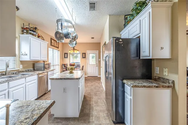 a kitchen with cabinets and stainless steel appliances