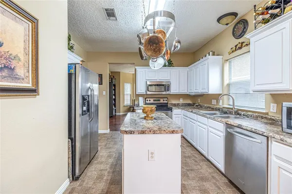 a kitchen with a refrigerator a sink and cabinets