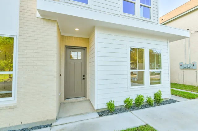a view of a brick house with potted plants