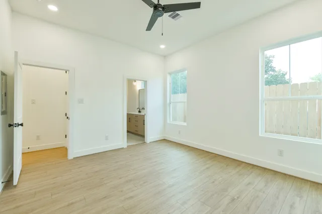 an empty room with wooden floor and windows