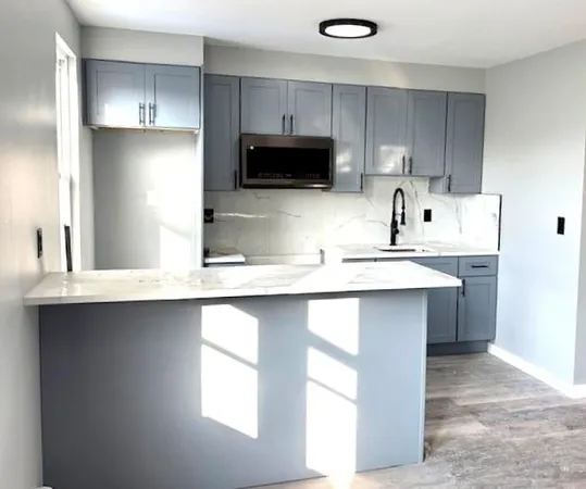 a kitchen with kitchen island a sink stainless steel appliances and cabinets