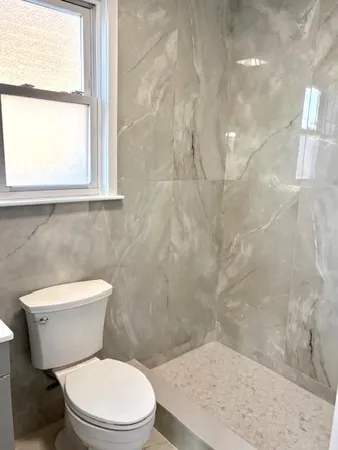 a white toilet sitting next to a window