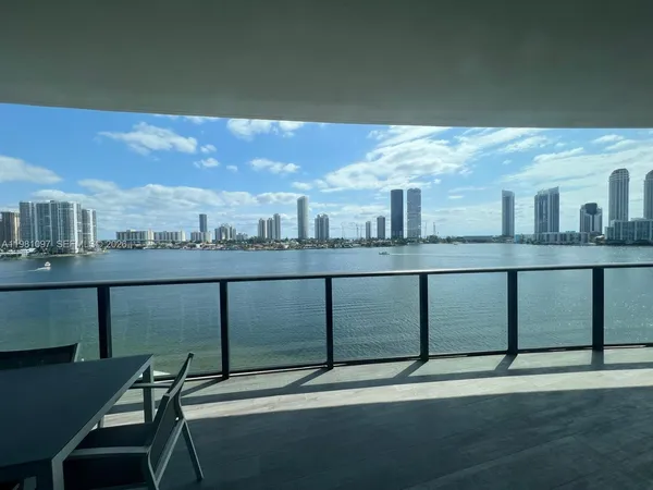 a living room with furniture and floor to ceiling windows