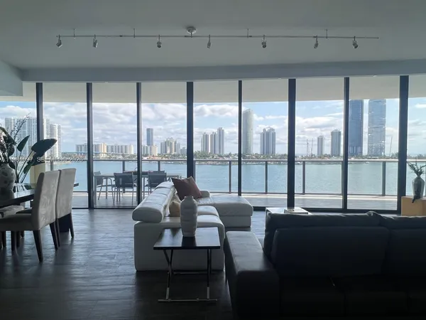 a living room with furniture and a floor to ceiling window