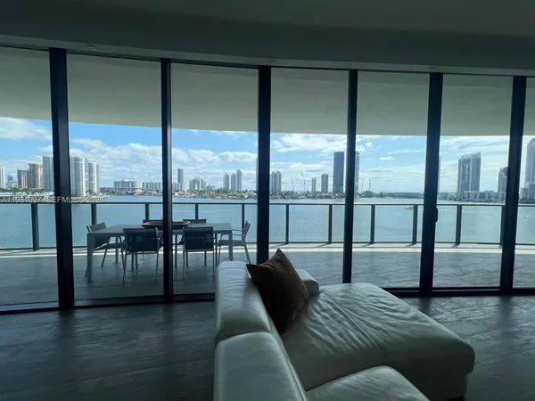 a very nice looking living room with furniture and floor to ceiling windows