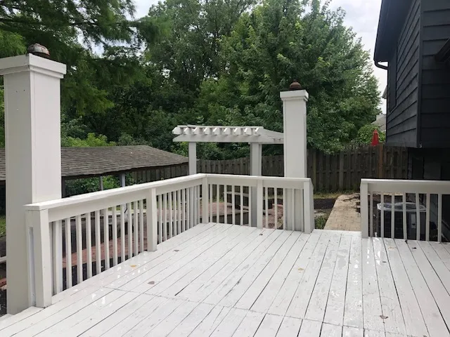 a view of a wooden deck and a yard with swimming pool